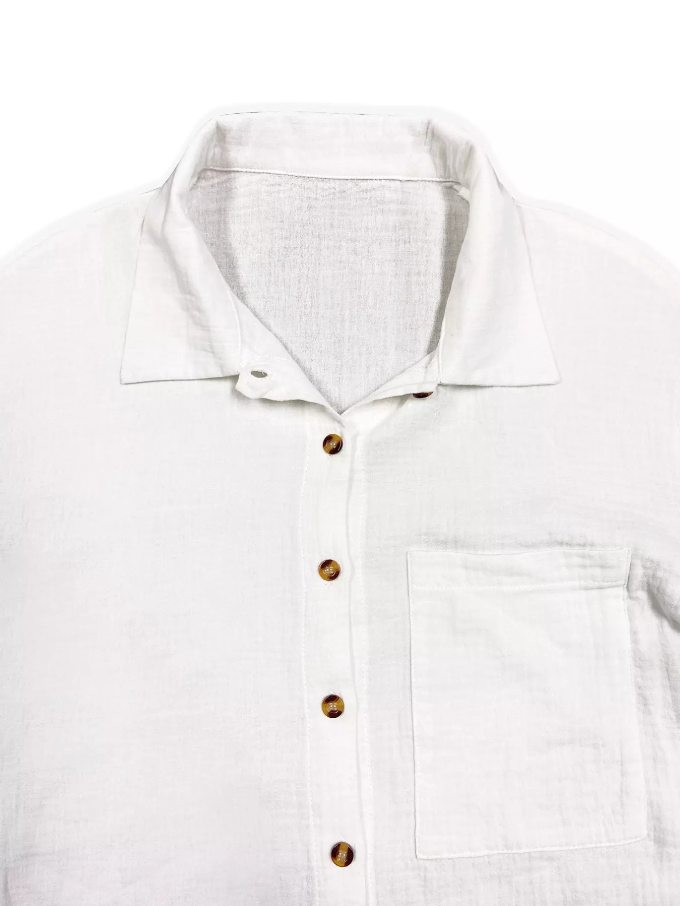 White linen button-up shirt with brown buttons and chest pocket.