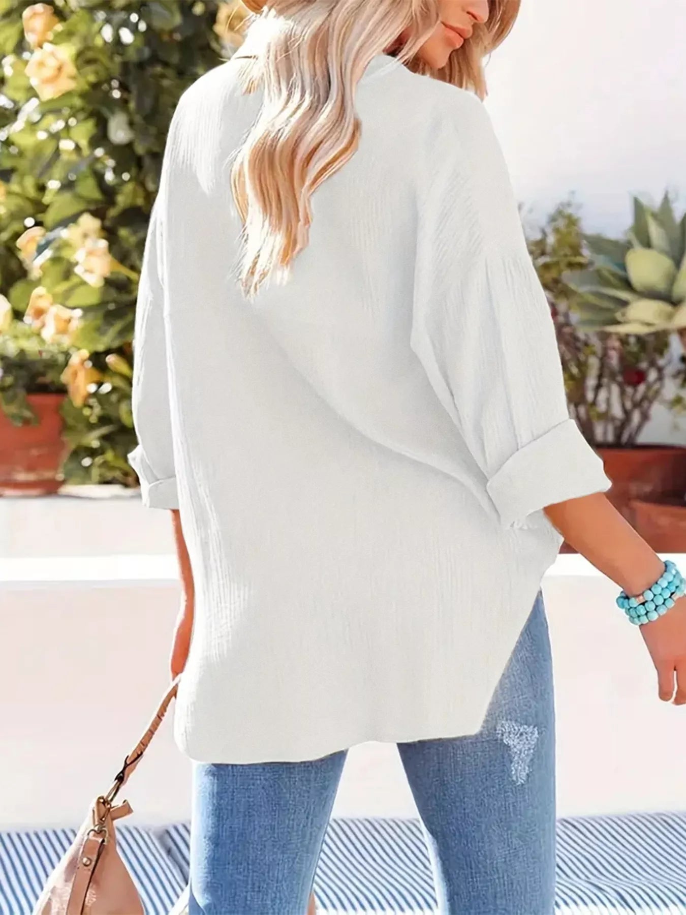 White oversized blouse with rolled sleeves, lightweight fabric.