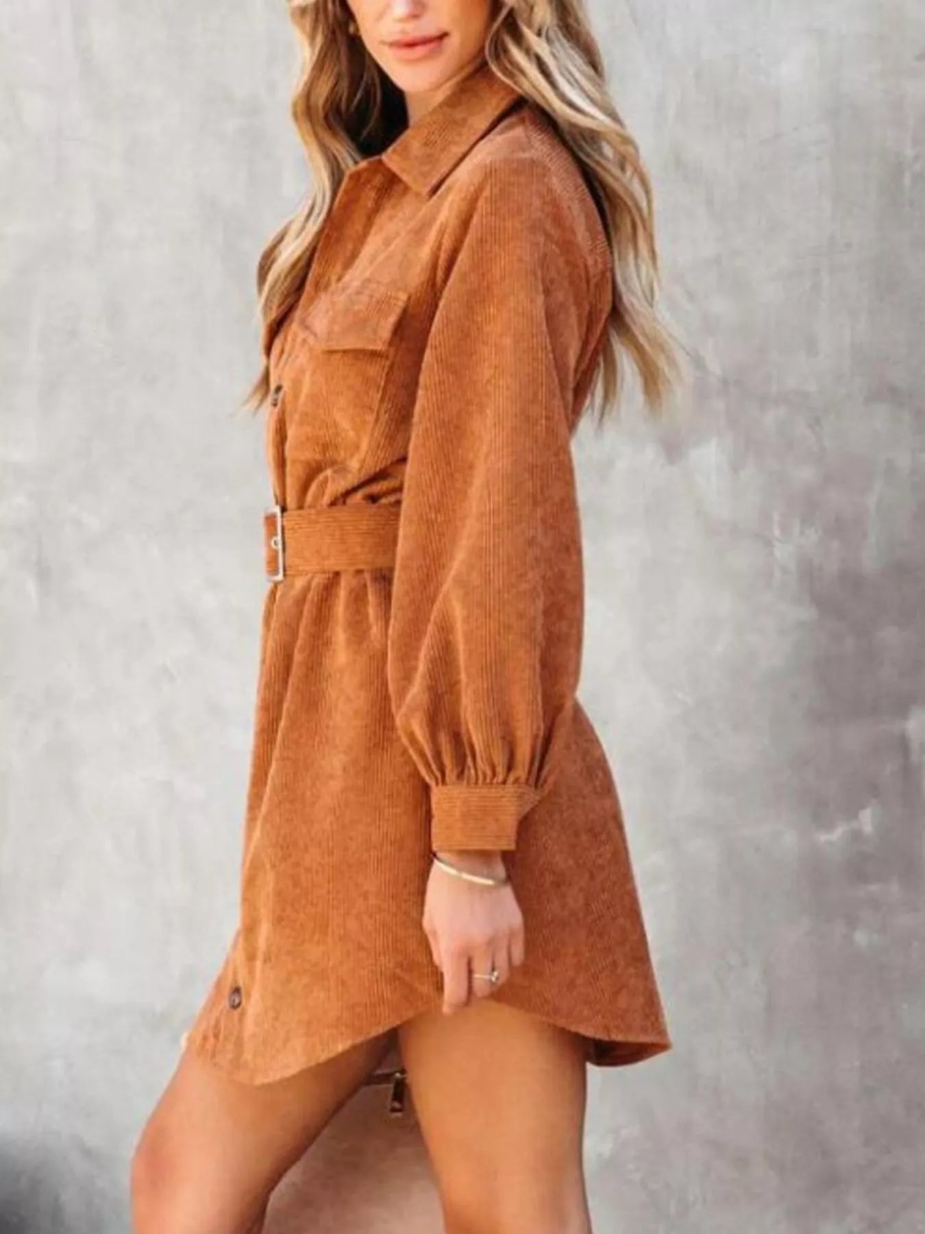 Rust brown corduroy shirt dress with long sleeves and belted waist.