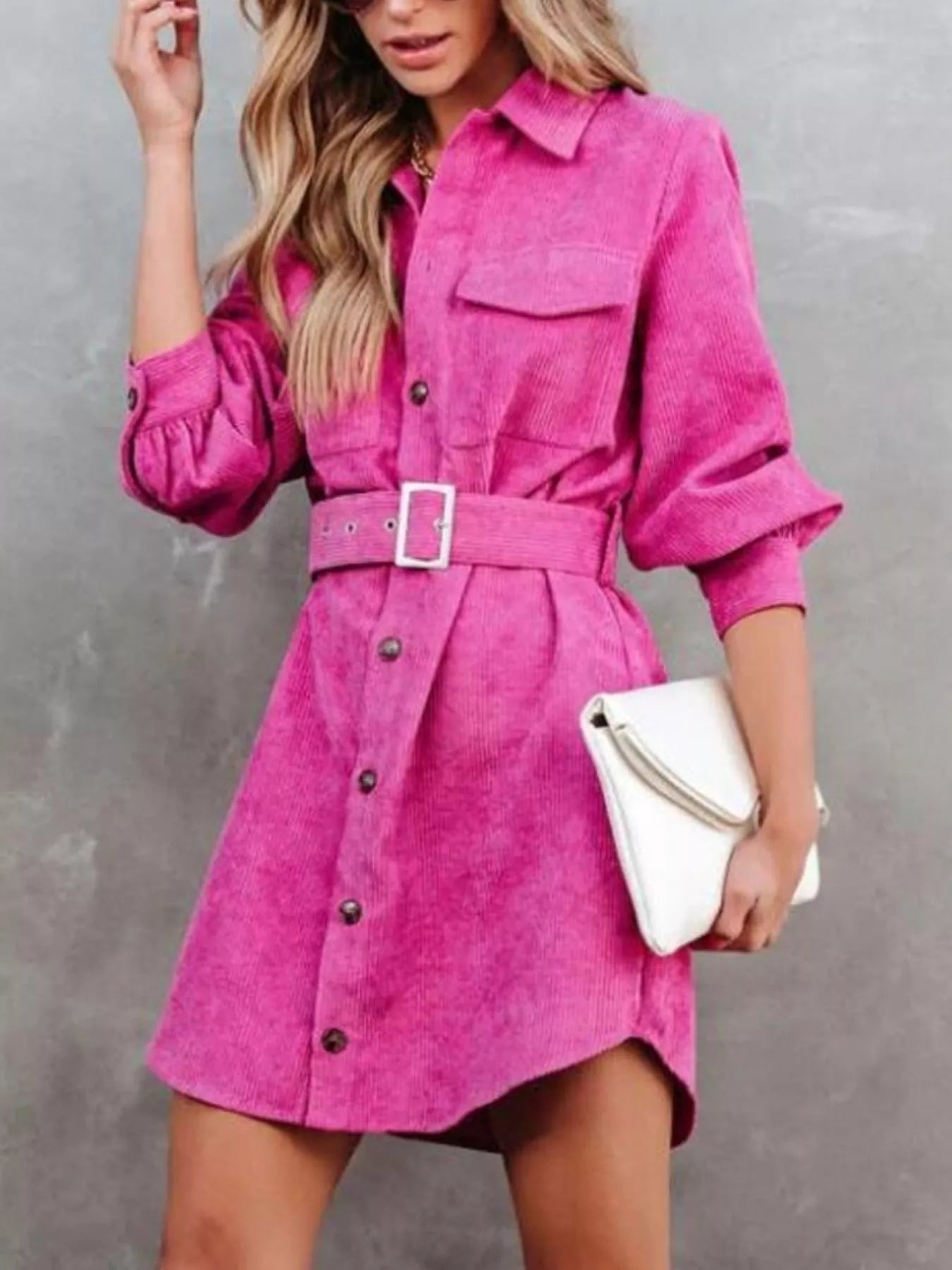 Pink corduroy shirt dress with belt and button front closure.