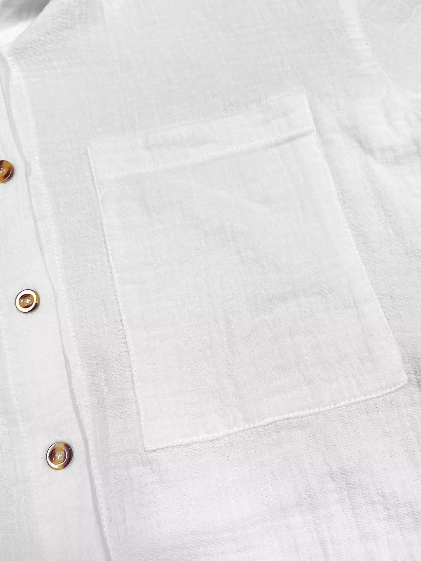 White linen shirt with front pocket and tortoiseshell buttons.