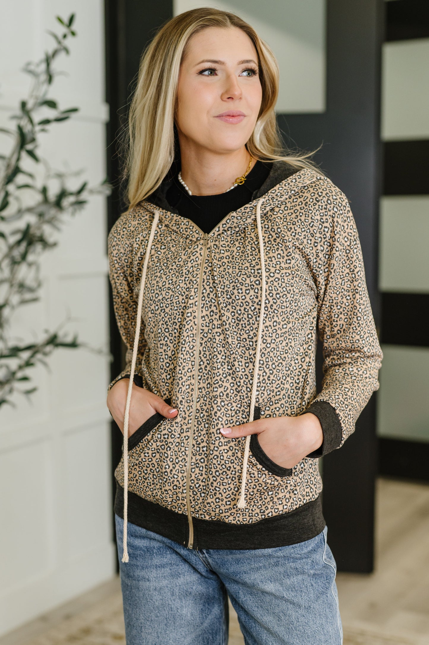 Woman wearing a patterned hoodie and jeans indoors