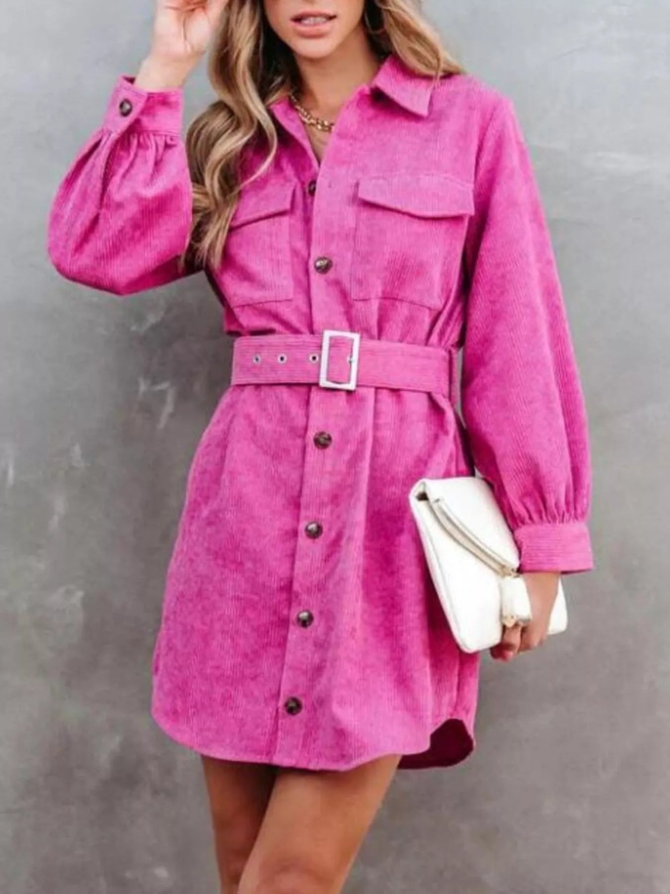Pink corduroy shirt dress with long sleeves and matching belt.