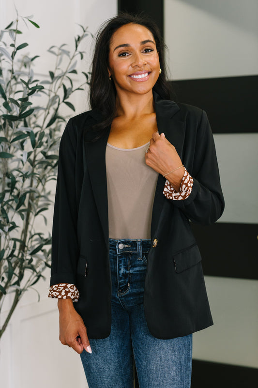 Woman in a black blazer, beige top and jeans for a comfortable fall work outfit