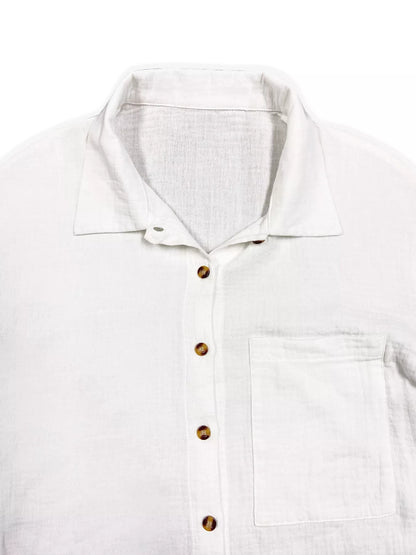 White linen button-up shirt with brown buttons and chest pocket.