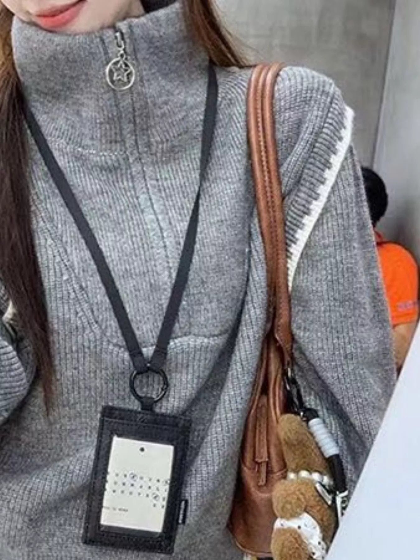 Gray ribbed knit pullover sweater with high collar and star zipper detail.