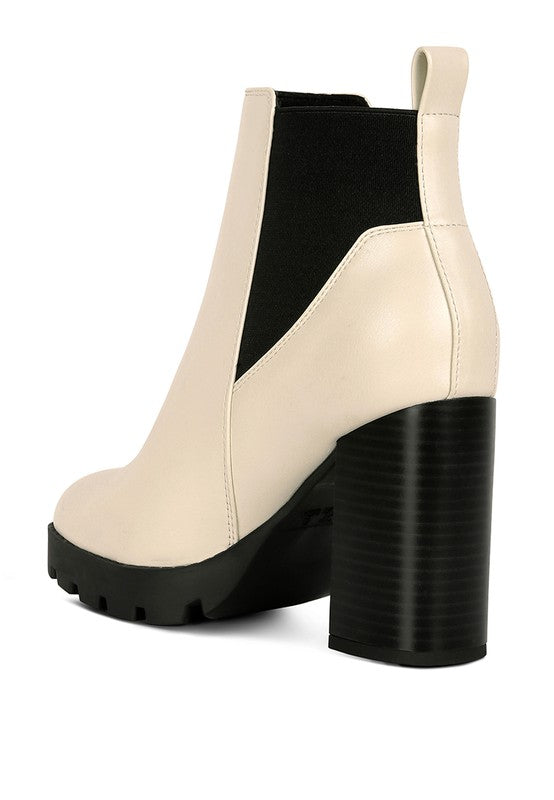 Beige Chelsea boot with black elastic panel, chunky block heel, and faux leather upper.
