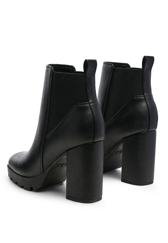 Black platform ankle boots with chunky high heels and faux leather finish.