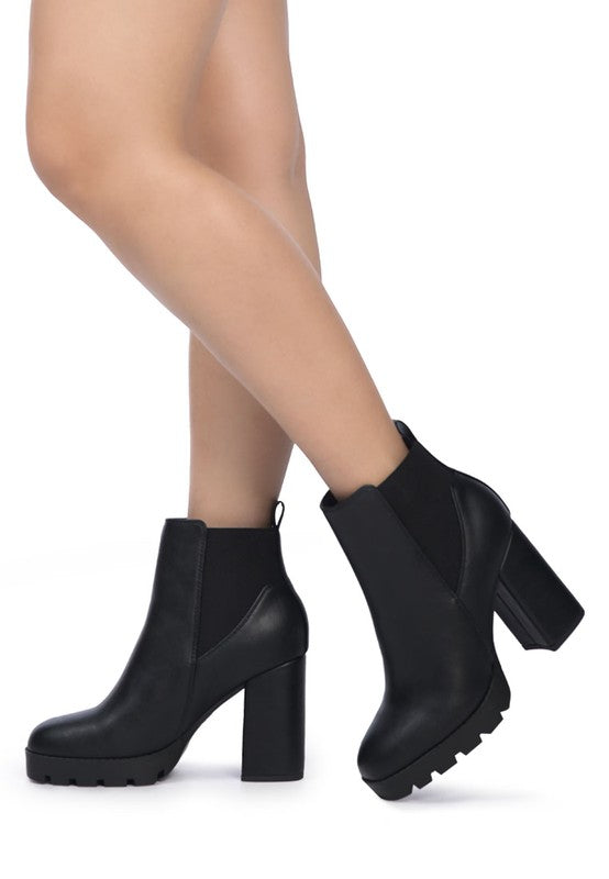 Black Chelsea ankle boots with block heel and stretch side panels, made of faux leather.