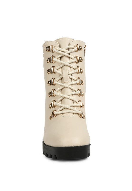 Ivory lace-up ankle boot with gold eyelets and a chunky black sole, made of faux leather.