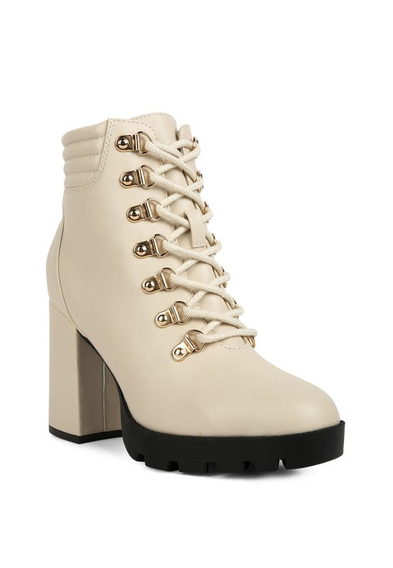 Ivory lace-up ankle boot with chunky heel and gold eyelets, made of faux leather.