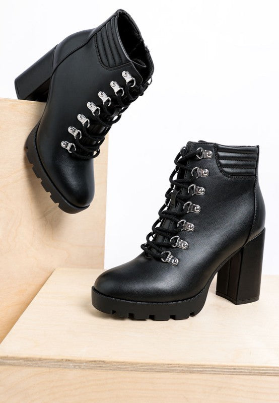 Black heeled ankle boots, lace-up style with silver eyelets, made from faux leather.