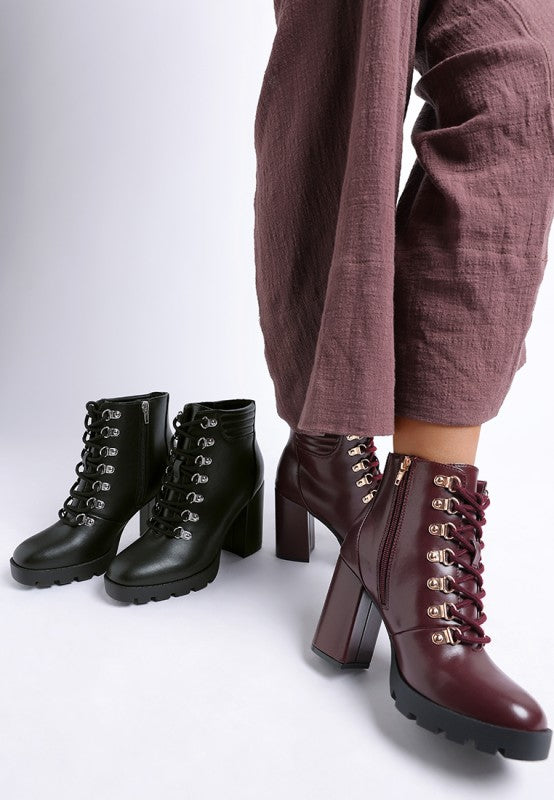 Burgundy and black lace-up heeled ankle boots with side zipper and chunky lug sole in faux leather.