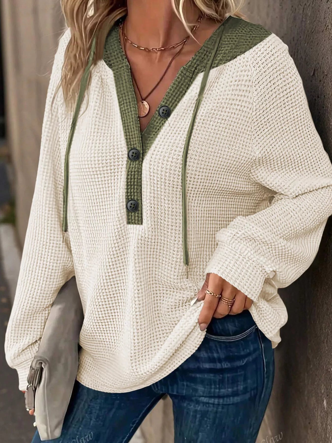 Cream and green waffle knit hoodie with buttons and drawstrings, made from soft textured fabric.