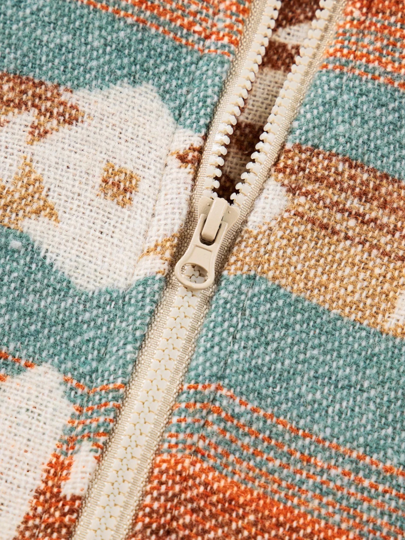 Plaid fleece jacket in teal, beige, and rust with a beige zipper and textured woven fabric.