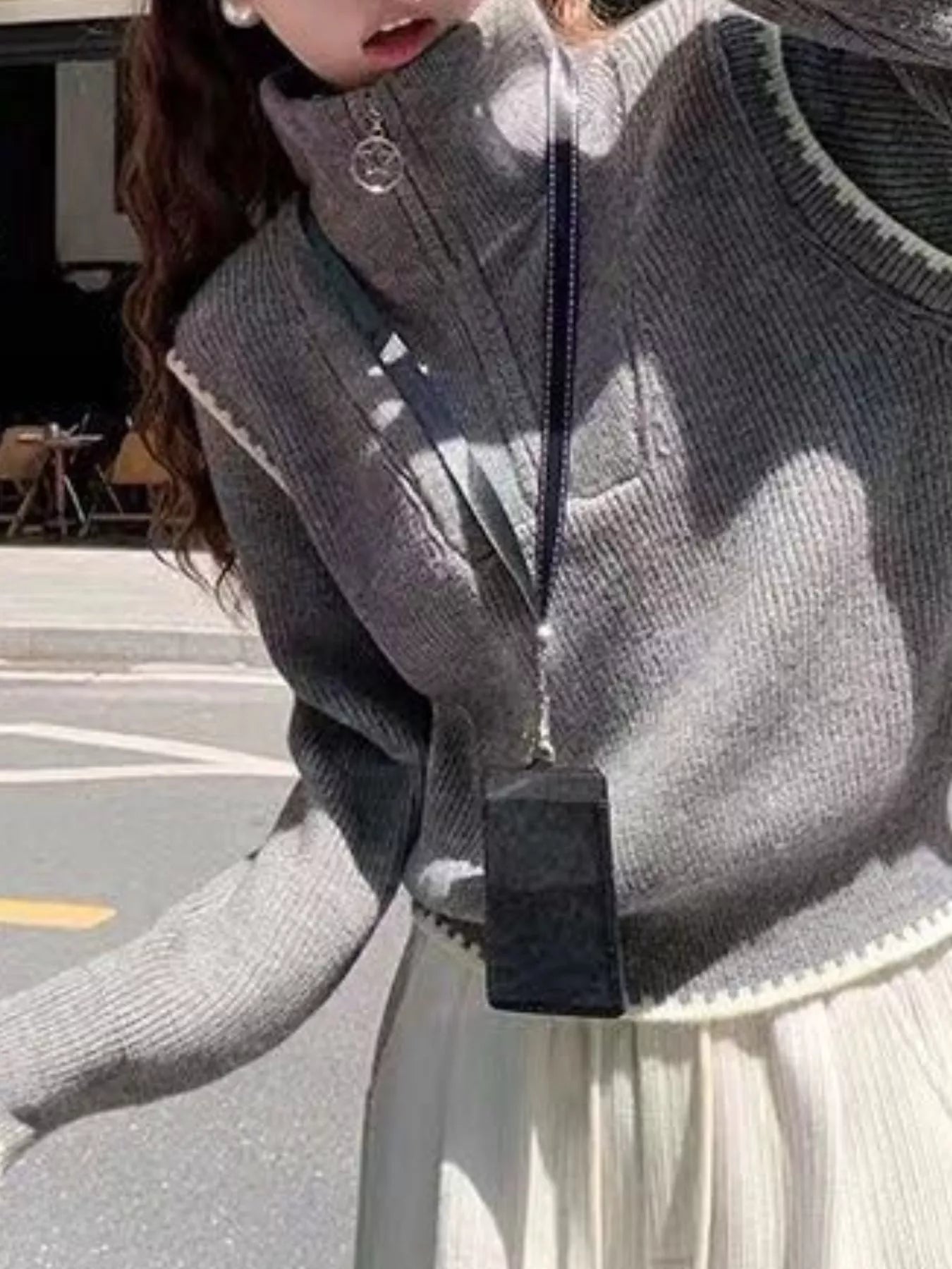 Gray zip-up knit sweater with high collar and ribbed texture.