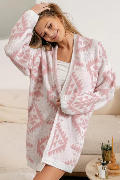 Pink and white geometric cardigan, open-front style, made of soft knit fabric.