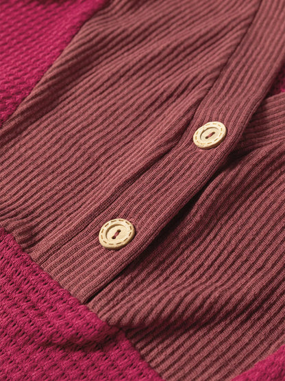 Colorblock cardigan in burgundy and magenta, ribbed knit fabric with wooden buttons.