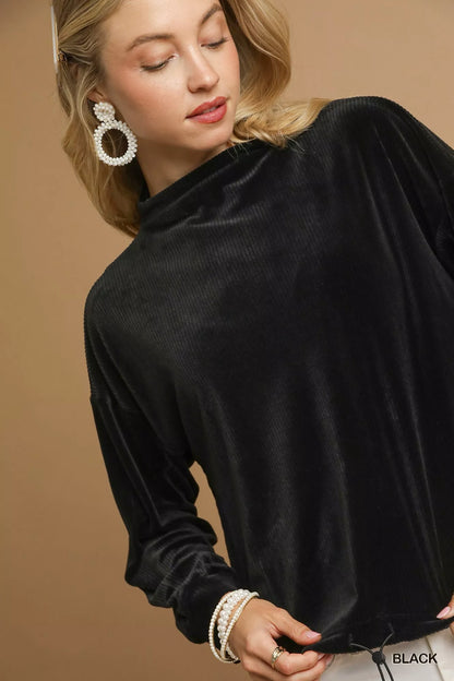 Black ribbed velvet top with long sleeves and adjustable drawstring hem.