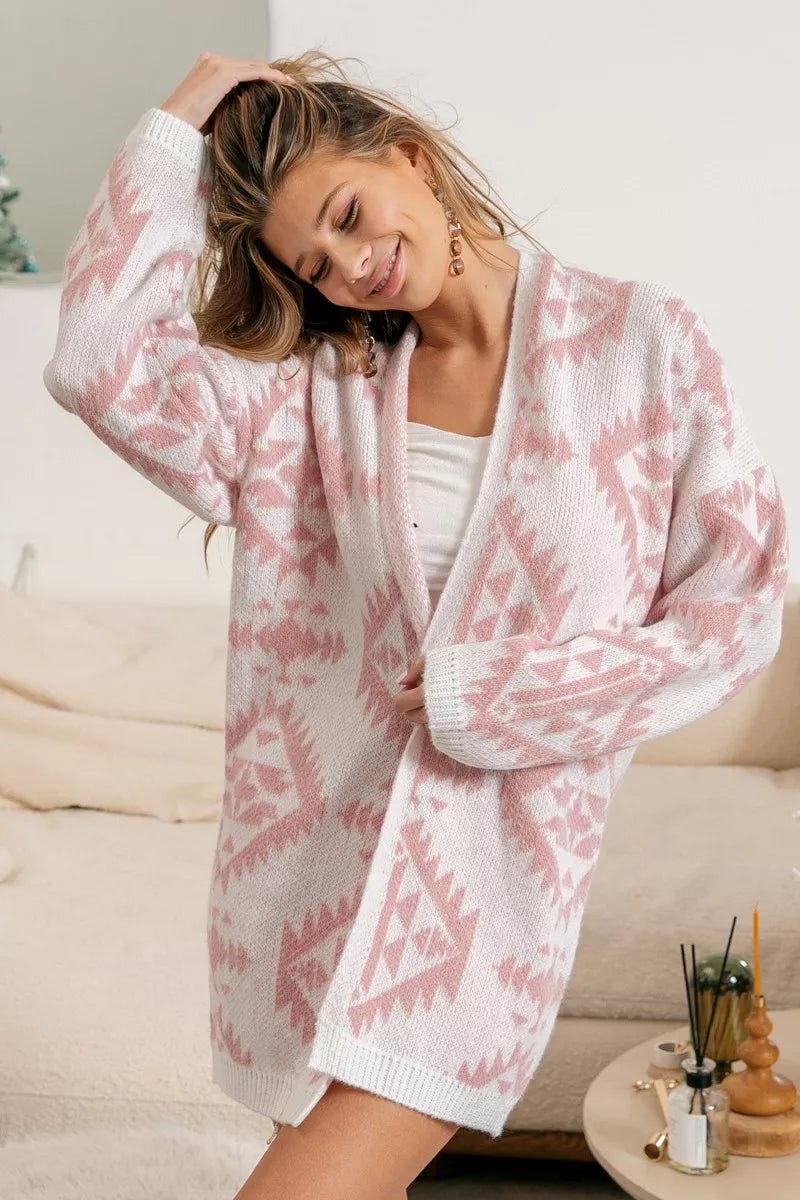 Pink and white knit cardigan with geometric pattern and soft, cozy fabric.