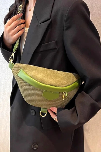 Olive green corduroy sling bag with adjustable strap and zip closure.