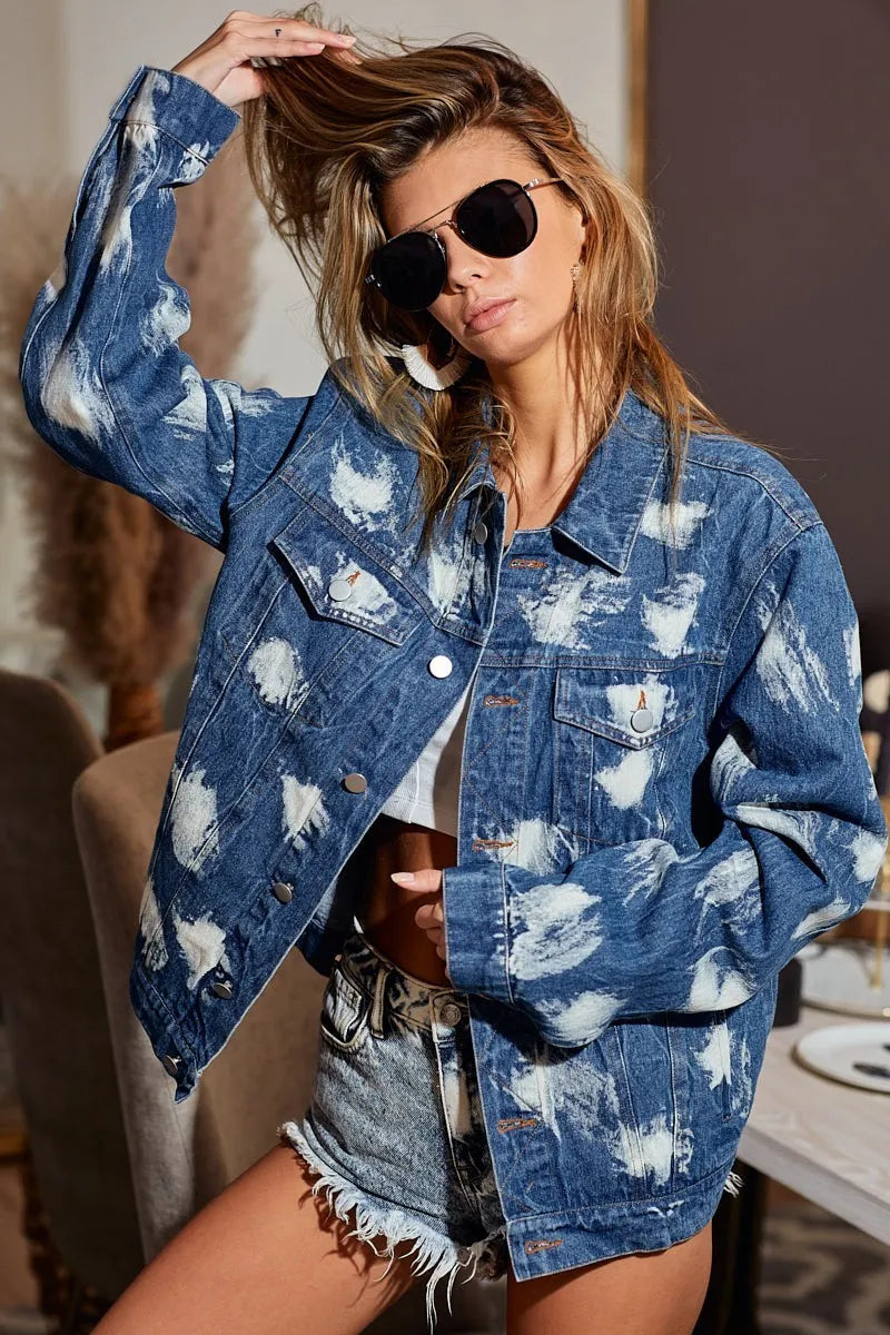 Blue distressed denim jacket with bleached patches and button-up front.