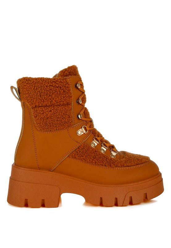 Rust orange lace-up boot with shearling panels and chunky rubber sole.