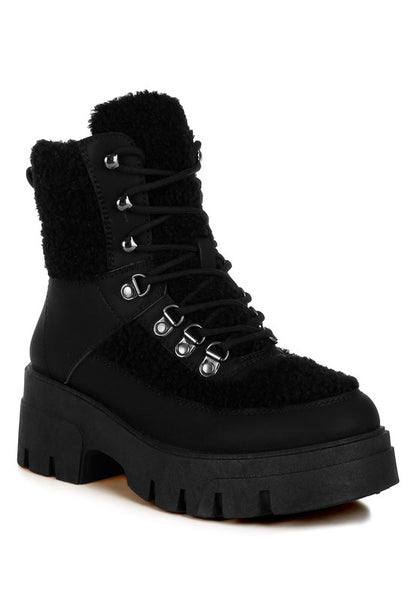 Black shearling lace-up boot with chunky sole and metal eyelets for added durability.
