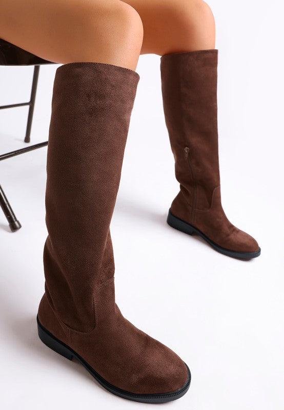 Brown suede knee-high boots with side zipper and flat sole.