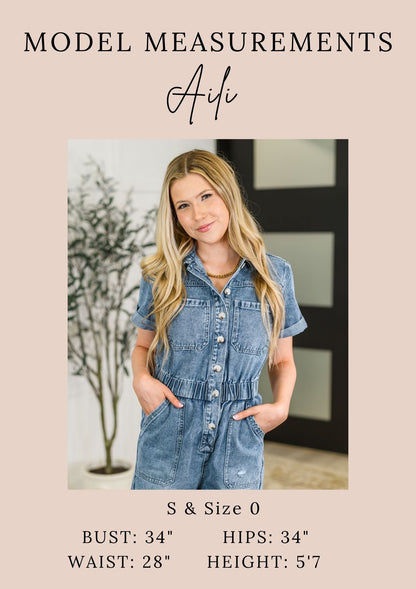 Aili blue denim romper with short sleeves and front buttons made from washed cotton fabric