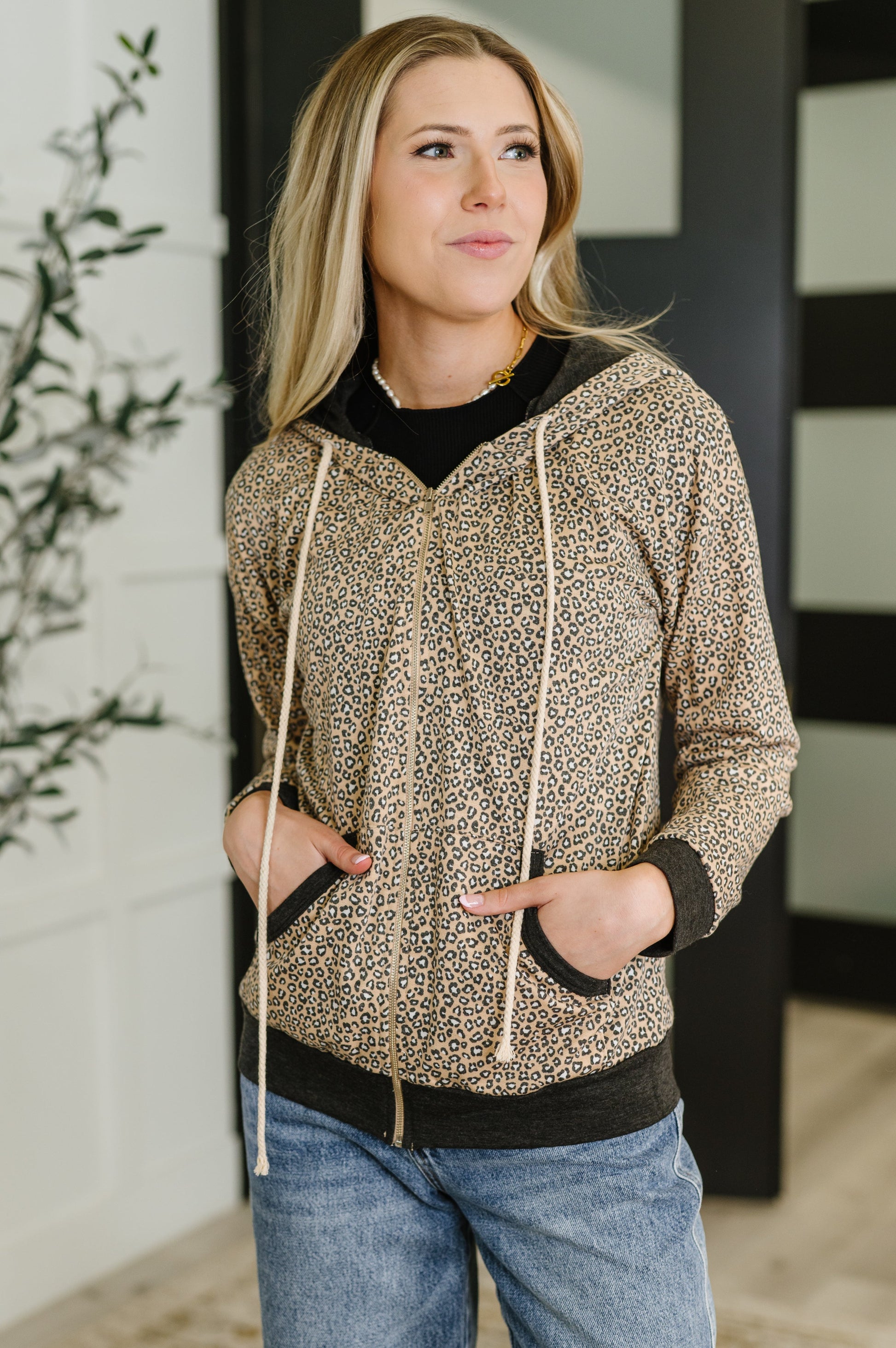 Woman wearing a patterned hoodie and jeans indoors