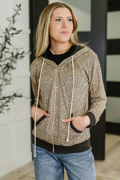 Woman wearing a patterned hoodie and jeans indoors