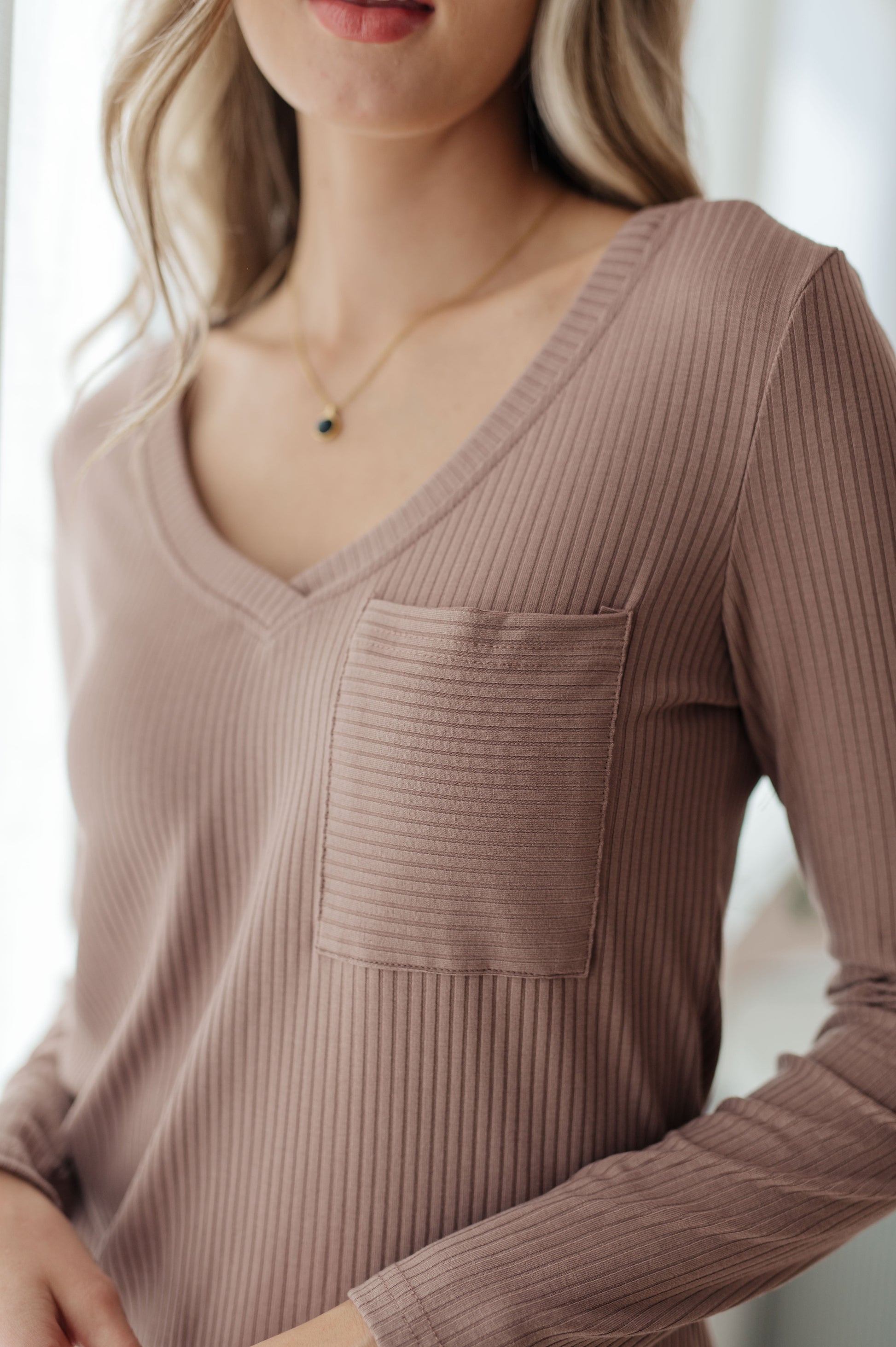 Mauve ribbed long-sleeve top with V-neck and front pocket made from soft knit fabric