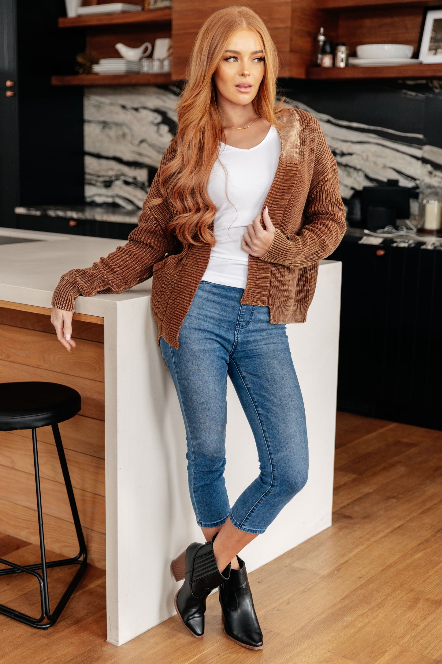 Brown ribbed cardigan with open front design and soft knit fabric.