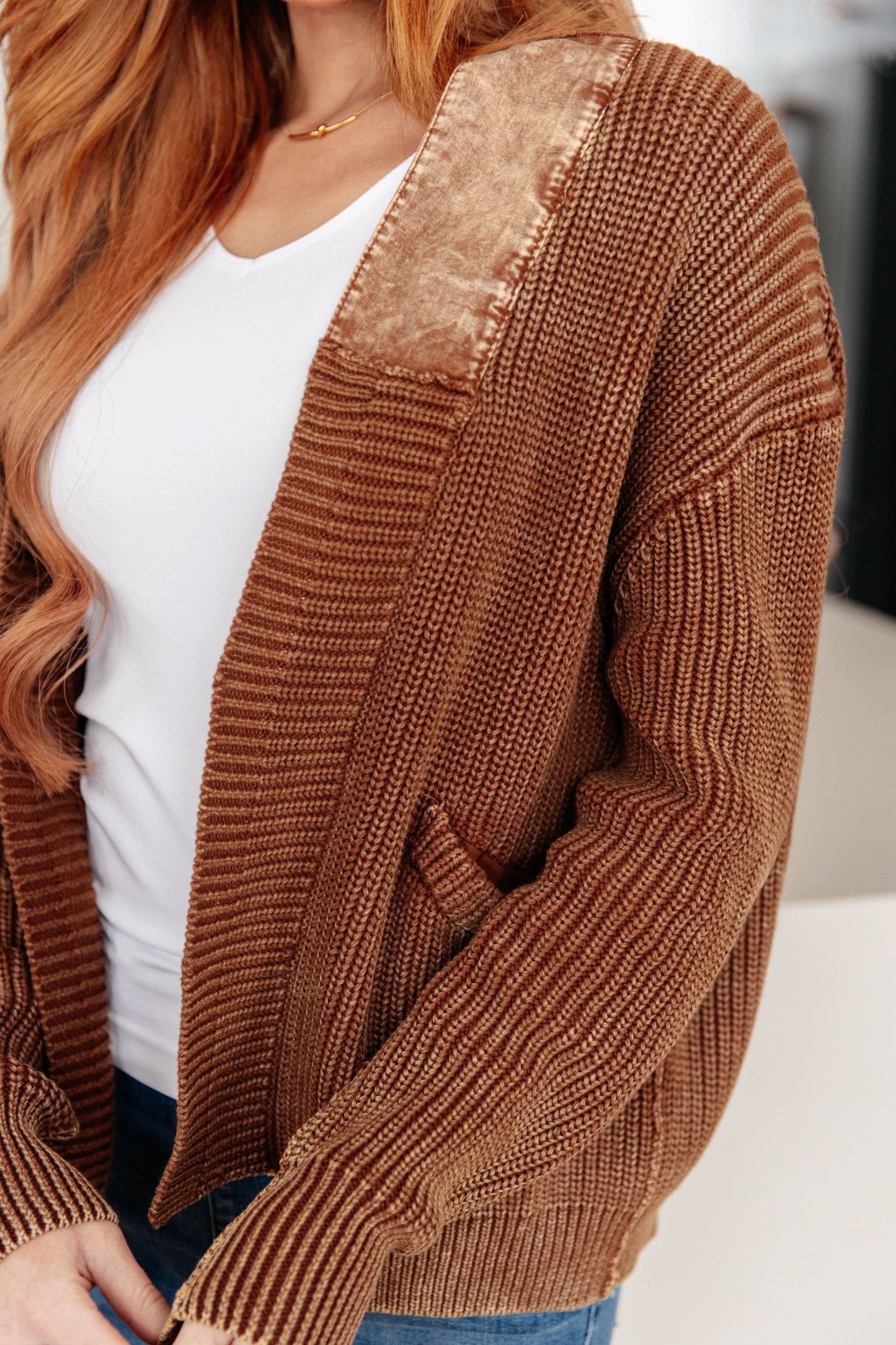 Brown knit cardigan with satin shoulder detail and front pockets.