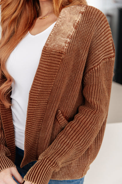 Brown knit cardigan with satin shoulder detail and front pockets.