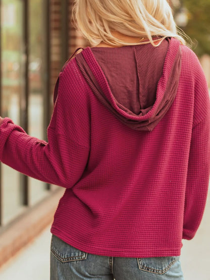 Magenta waffle knit hoodie with contrast hood and relaxed fit.