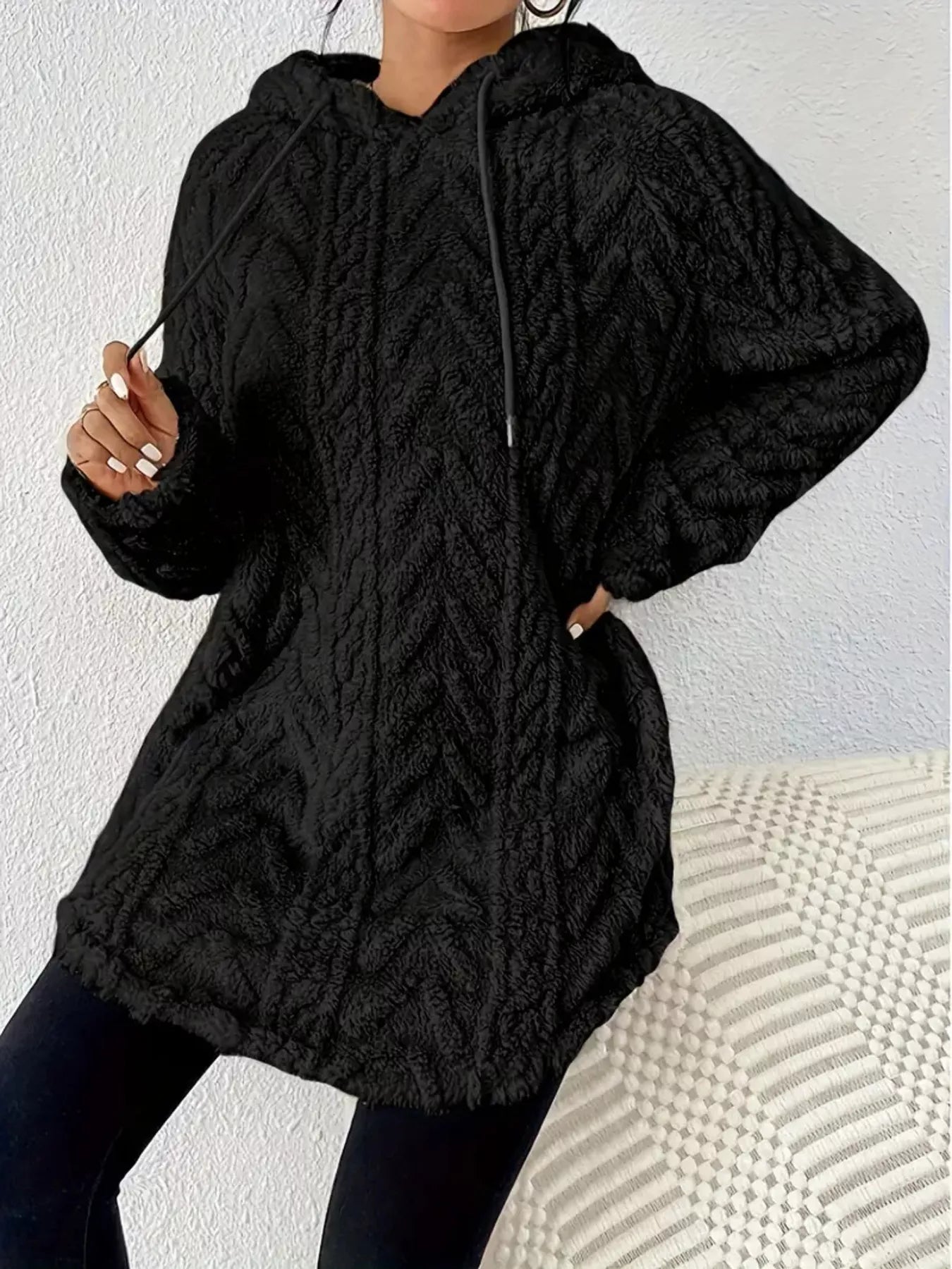 Black hooded pullover sweater with drawstrings, made from soft faux fur material.