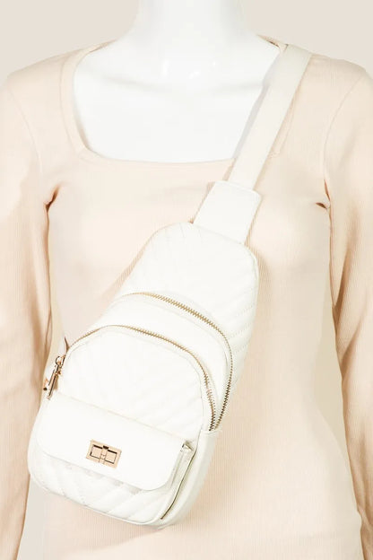 White quilted sling bag with gold zippers and adjustable strap.