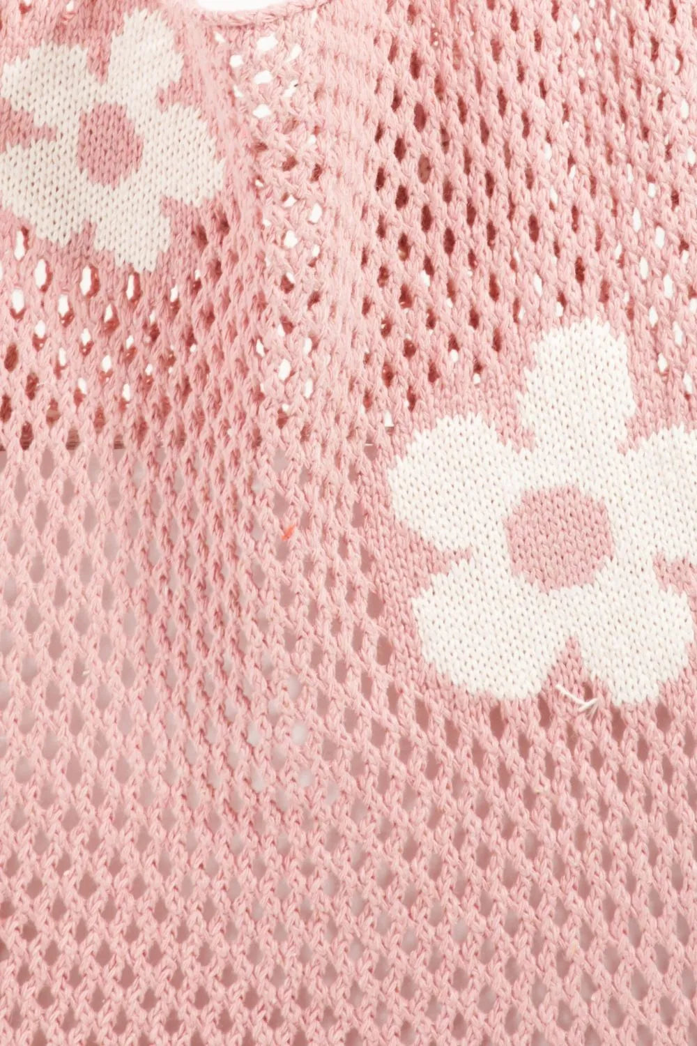 Pink crochet top with white floral pattern and open-knit cotton material.