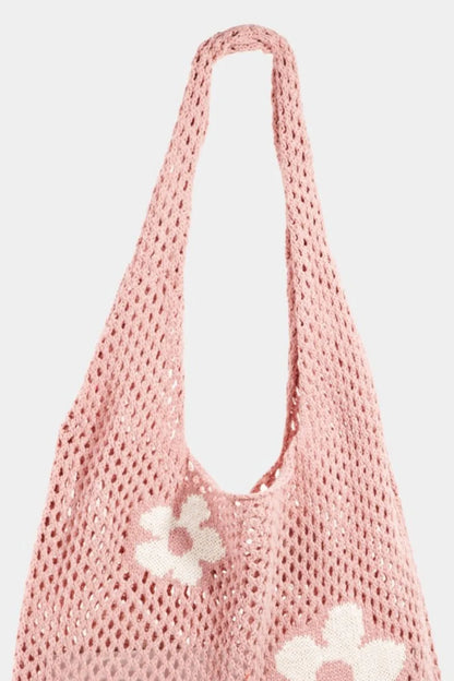 Pink crochet shoulder bag with white flower pattern and open mesh design.