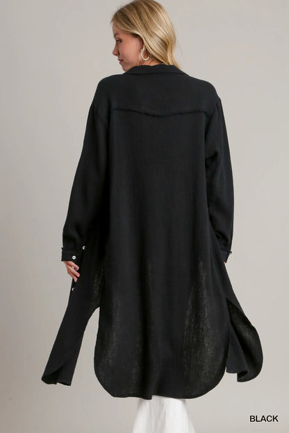 Black long shirt dress with side slits, made of lightweight textured fabric.